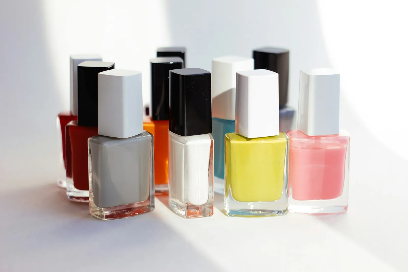 Bright nail polish bottles in red, yellow, pink and white
