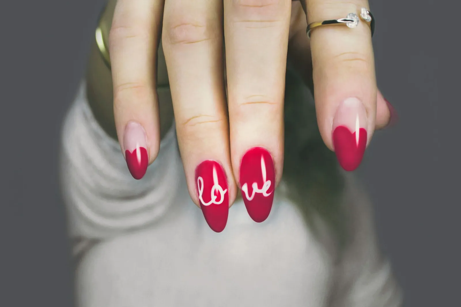 Long almond nails in red and pink with hand-painted love nail art